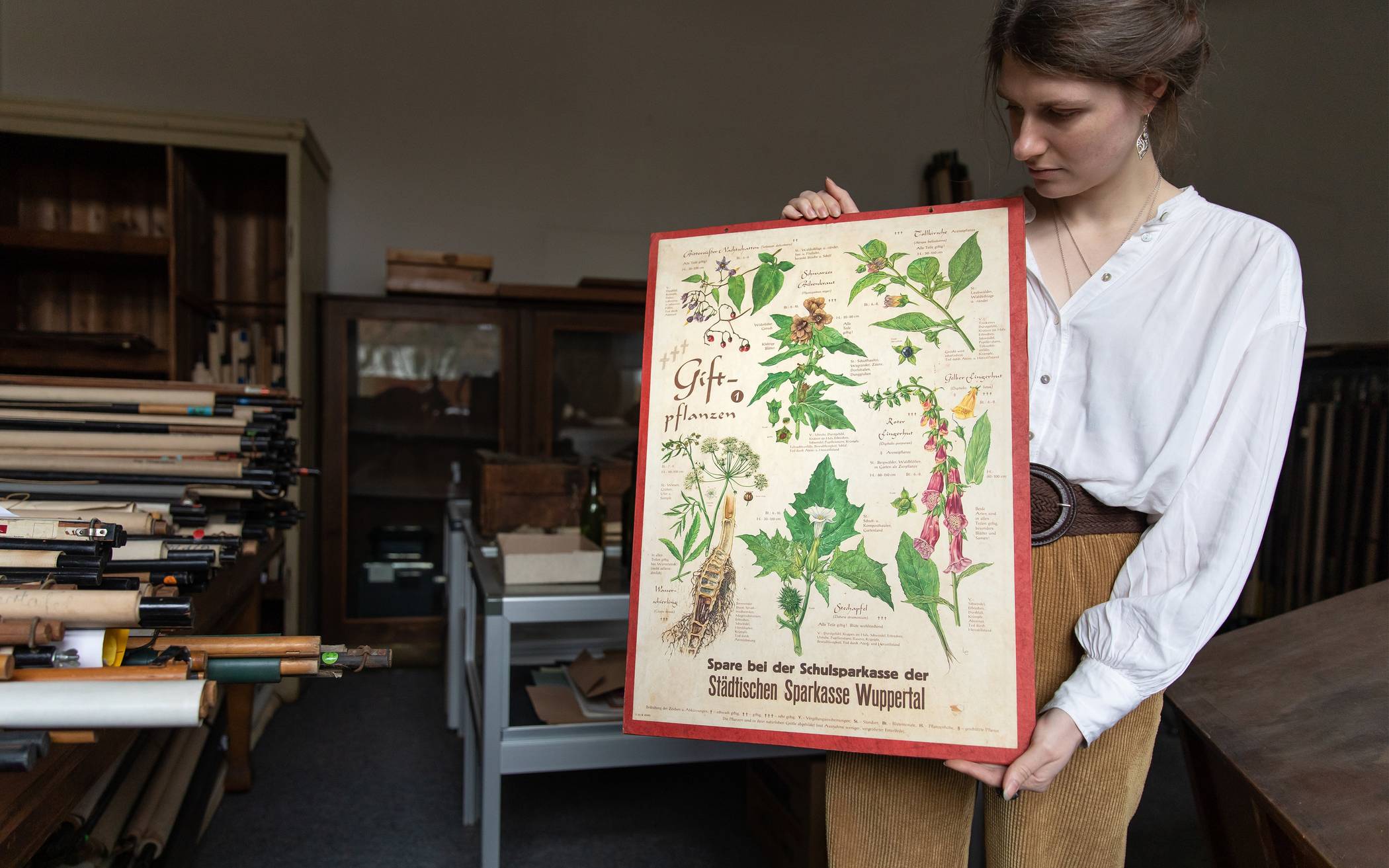  Melody Stach mit einer historischen Pflanzenkarte aus der schulhistorischen Sammlung in Vohwinkel.  
