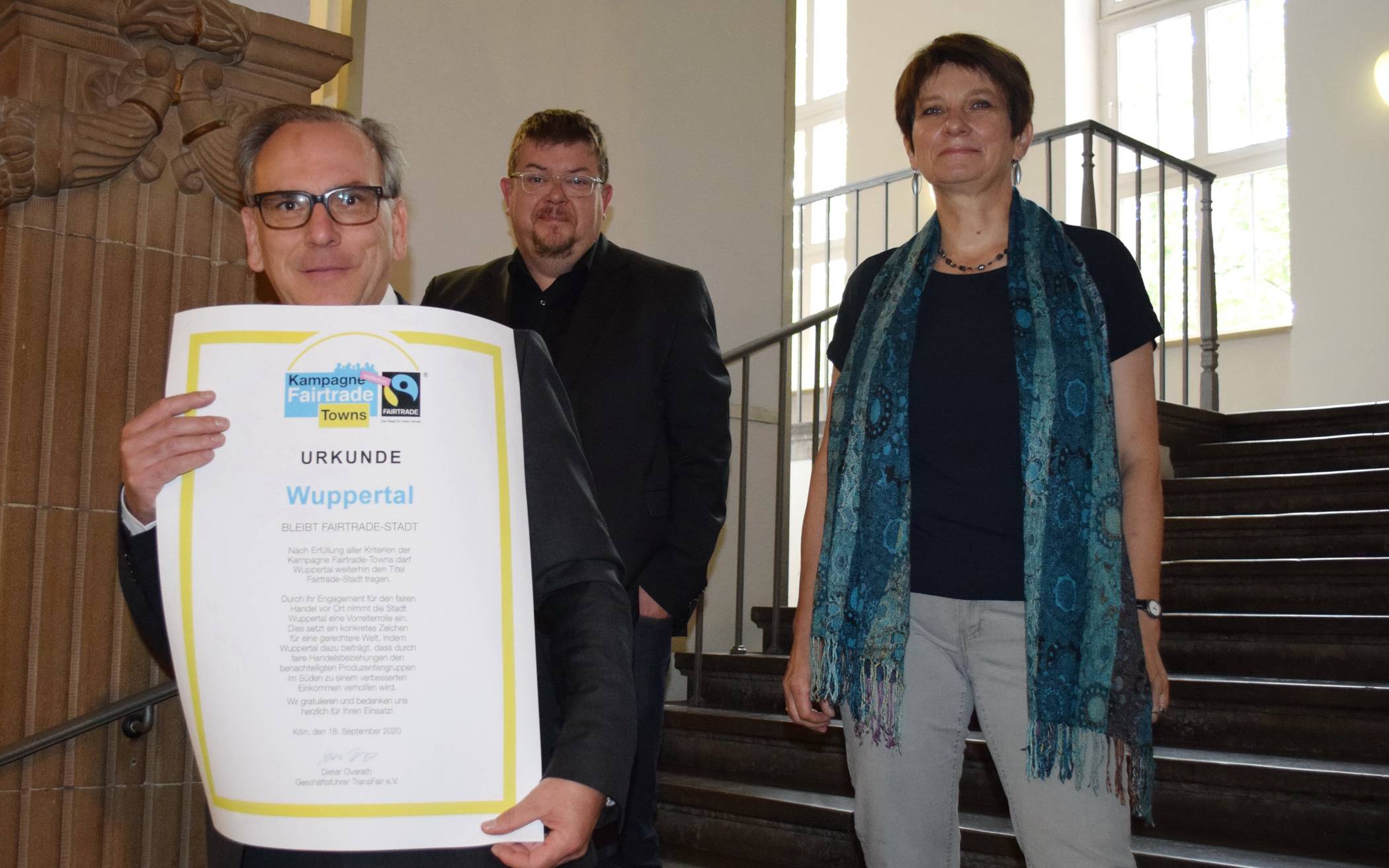  Von li: Oberbürgermeister Andreas Mucke, Dezernent Frank Meyer und Susanne Varnhorst mit der Urkunde, die Wuppertal als „Fairtrade-Town“ auszeichnet. 